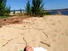 Jerking off as a bikini woman lies on the beach